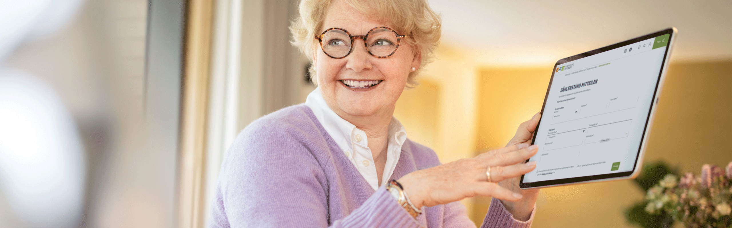 Frau informiert sich auf Tablet zu Ökostrom- und Erdgas-Tarifen