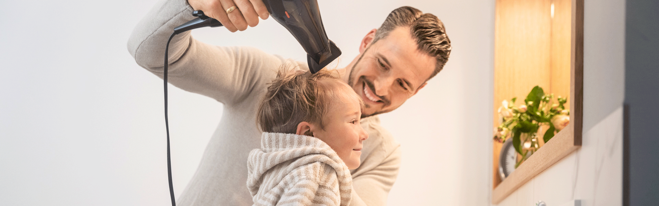 Vater föhnt Sohn die Haare